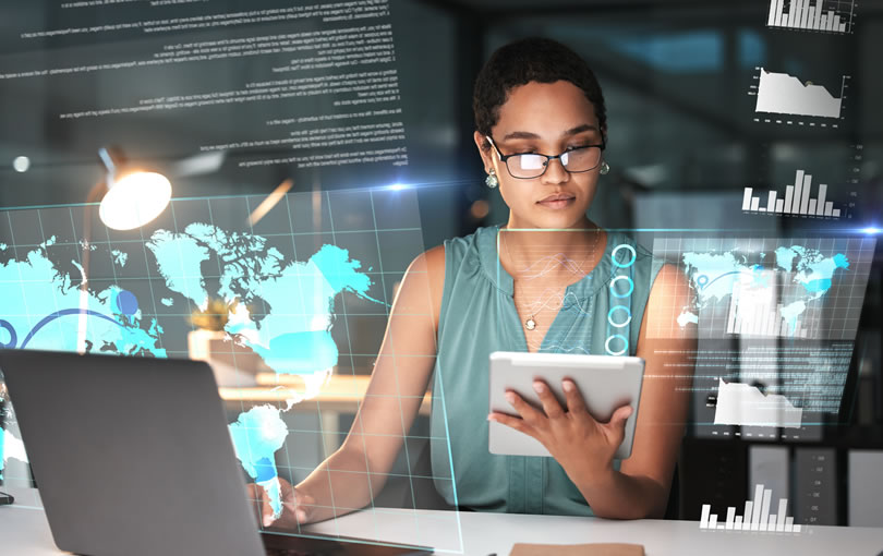 Uma mulher em traje profissional usando um tablet enquanto cercada por displays digitais futuristas e visualizações de análise.